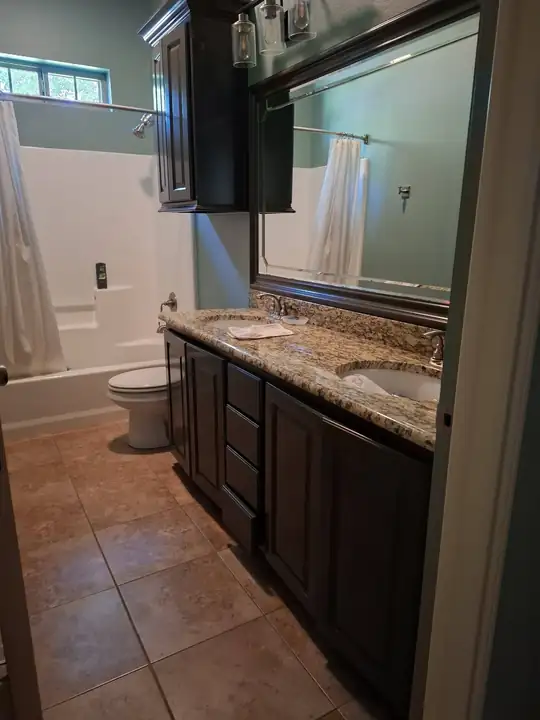 Double vanity with a big mirror and the shower beside it