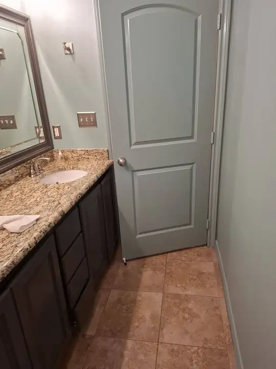 Vanity beside a door with a tile floor
