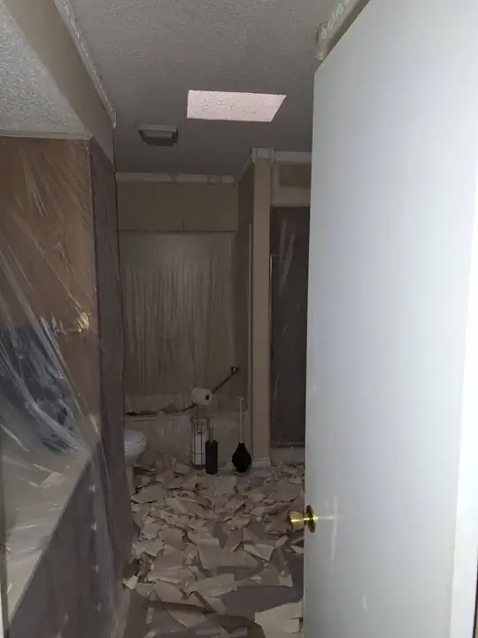 Bathroom tile being demolished, poly on the walls