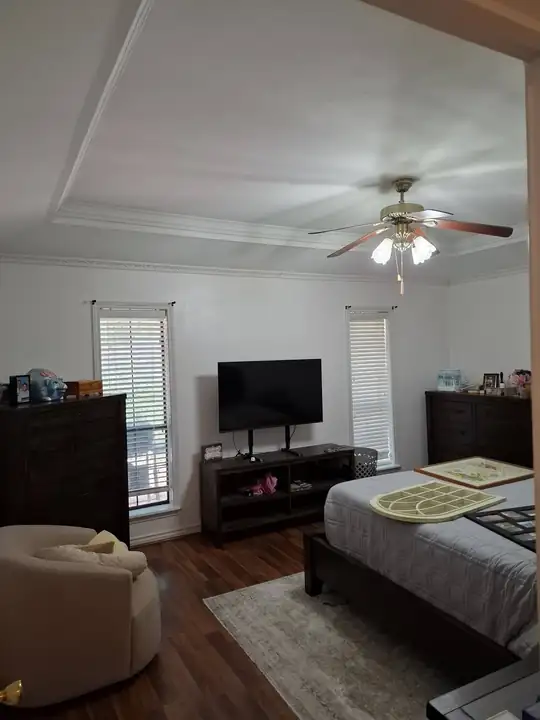 The finished bedroom: smooth tray ceiling, crown molding, white walls and a ceiling fan