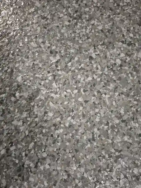 Macro of grey, white and black flake chips in a floor coating