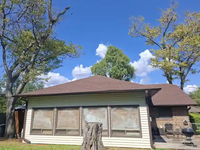 Back sunroom finished, cream siding under blue sky