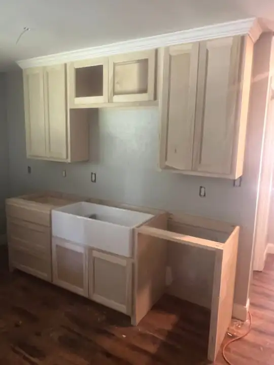 Unpainted cabinets and a farmhouse sink, work in progress