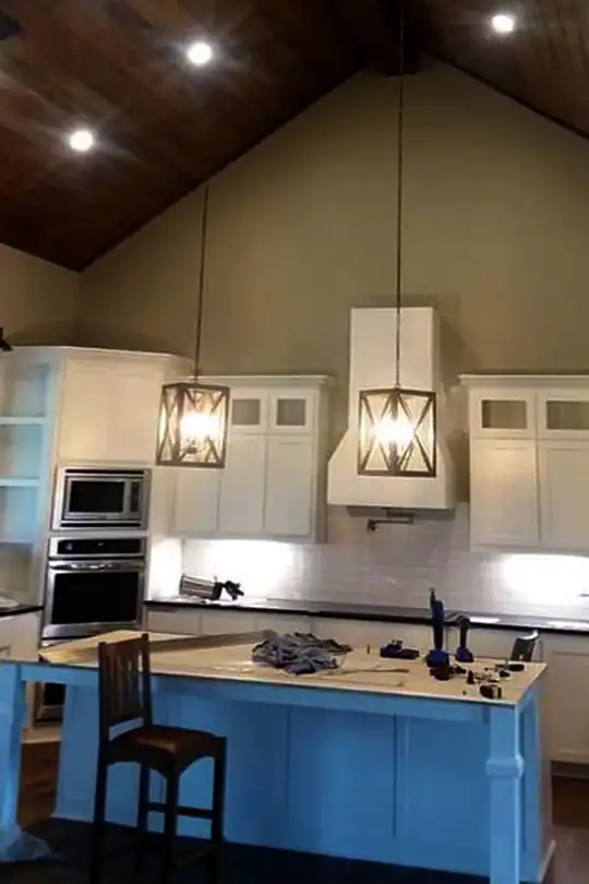 Kitchen with a blue island, white cabinets, a timber ceiling and pendant lights