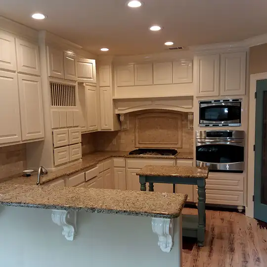 Cream kitchen cabinets with granite counters and a wall oven