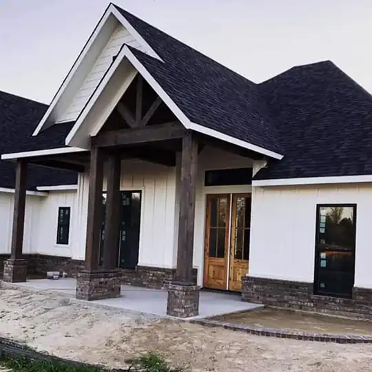 White new build with a timber gable porch and a brick base